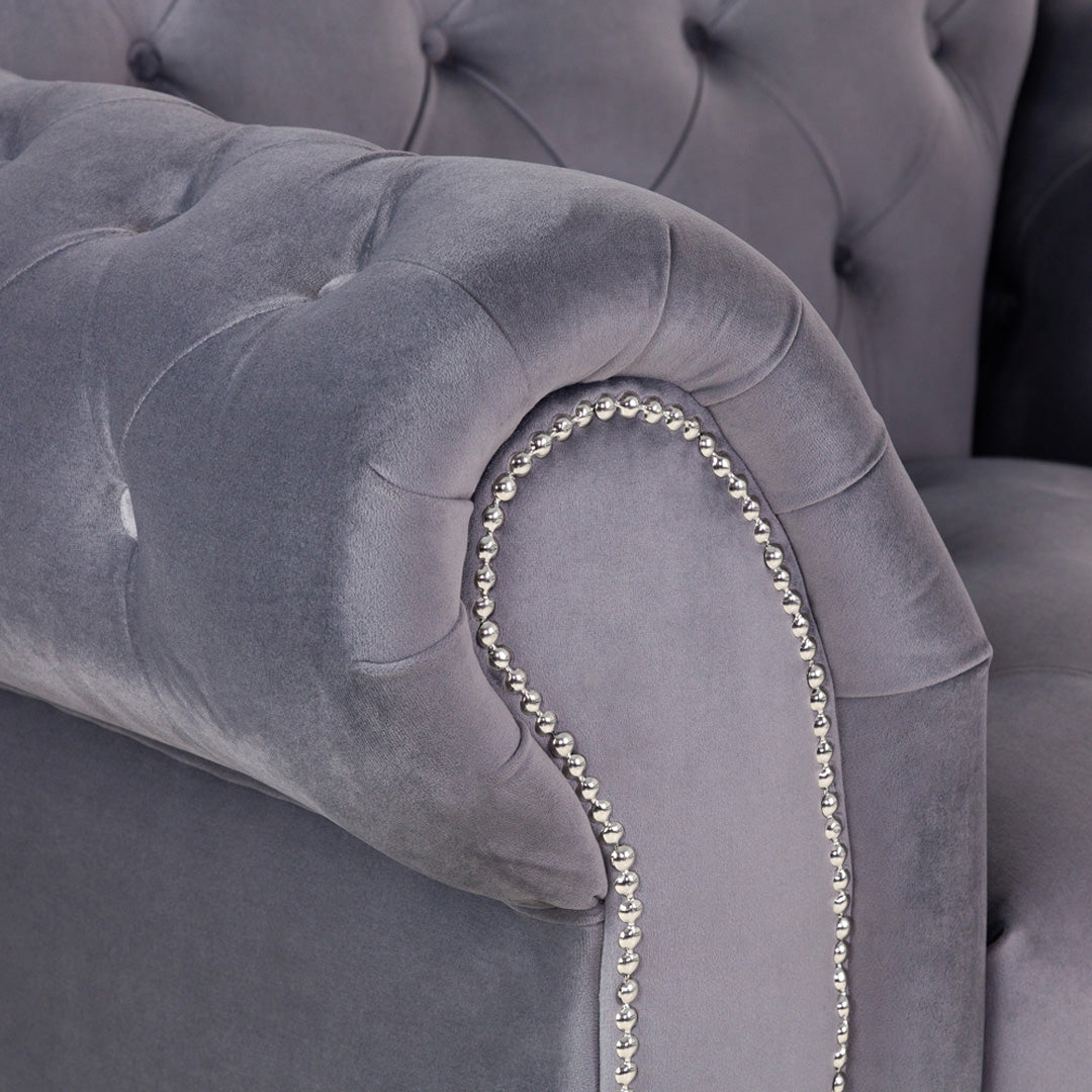 "Compact velvet-like fabric sofa with classic tufted back and padded arms"